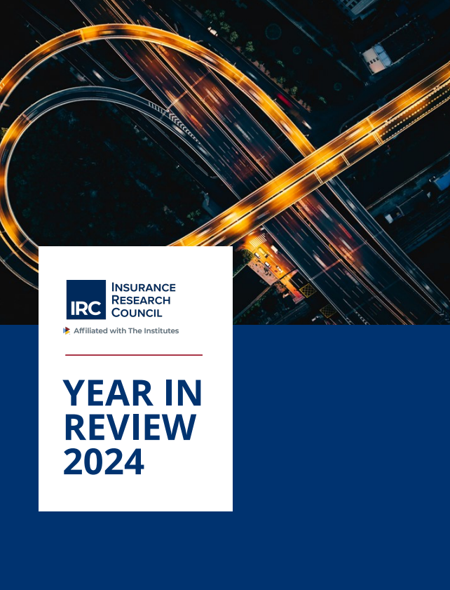 Professional annual report cover featuring aerial view of illuminated highway interchange at night with golden light trails from traffic, overlaid with Insurance Research Council logo and "Year in Review 2024" text on blue background.