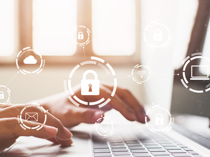 Closeup of hands typing on a laptop and images of a security lock and technology icons are overlaid on top of the image.  