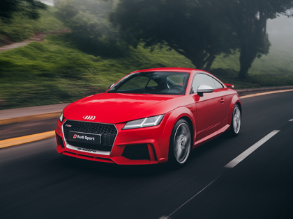 A red car driving fast on a road