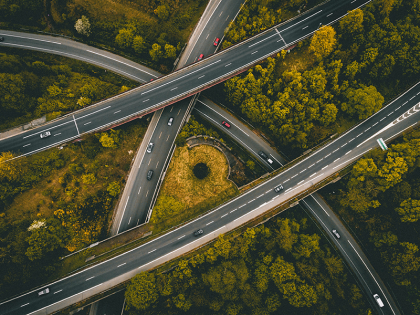 An overhead view of crisscrossing highways, each with cars driving on them. 